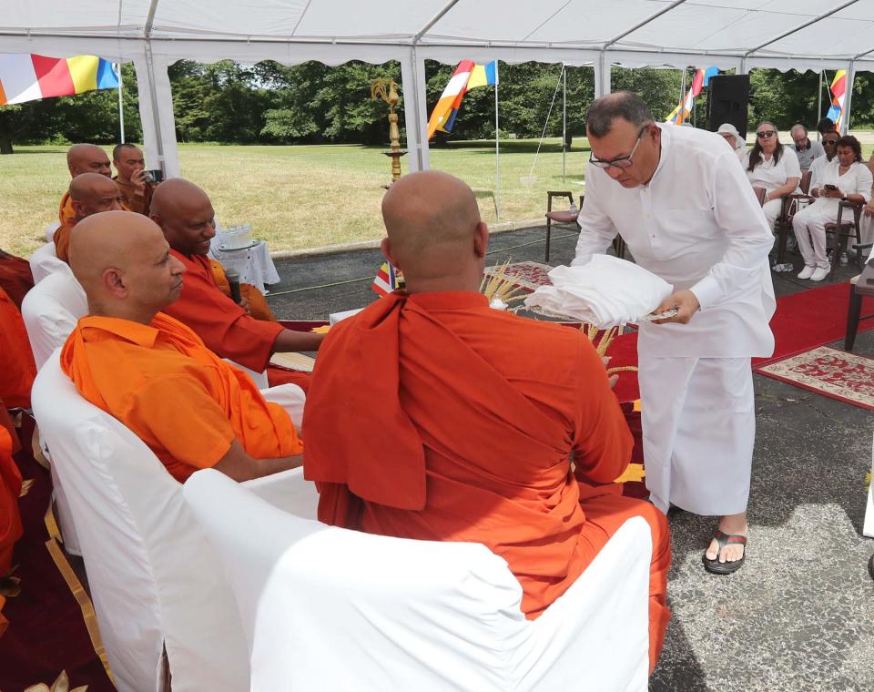 Sri Lankan Ambassador to the U.S. Mahinda Samarasinghe presents the Buddhist monks with a ceremonial cloth.