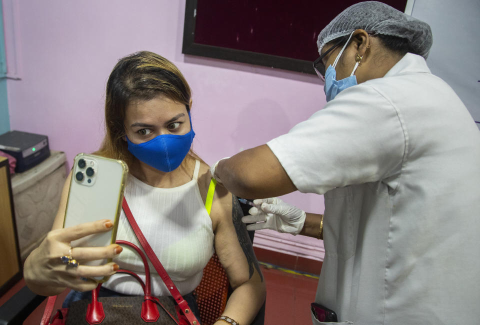 A woman takes selfie as she receives the Covishield vaccine against COVID-19 in Gauhati, Assam, India, Monday, May 17, 2021. (AP Photo/Anupam Nath)