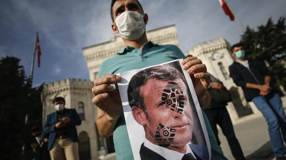 Ein junger Mann hält ein mit einem Schuhabdruck versehenes Foto von Emmanuel Macron, Präsident von Frankreich, in die Kamera. Recep Tayyip Erdogan, Präsident der Türkei, griff Macron ein zweites Mal verbal an und warf ihm Islamfeindlichkeit vor.