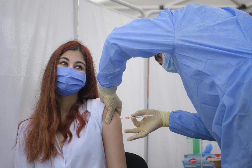 A girl gets a Pfizer BioNTech COVID-19 vaccine in Bucharest, Romania, Wednesday, June 2, 2021. Romania has started the vaccination campaign for children between the ages of 12 and 15. (AP Photo/Andreea Alexandru)