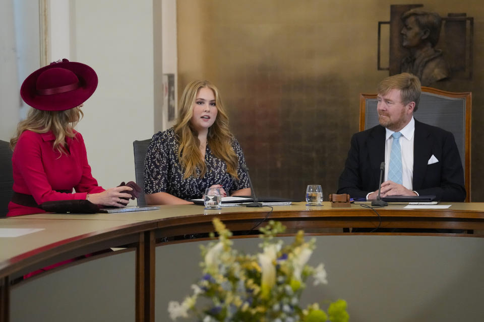 Heir to the Dutch throne Princess Amalia speeches as she takes an honorary seat at the Council of State, the highest government advisory body, while her mother Queen Maxima, left, and father King Willem-Alexander, right, listen, in The Hague, Netherlands, Wednesday, Dec. 8, 2021, one day after celebrating her eighteenth birthday. (AP Photo/Peter Dejong, Pool)