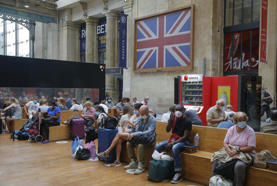 Passengers wait next to the Eurostar Terminal at the Gare du Nord train station in Paris, Friday, Aug. 14, 2020. British holidaymakers in France were mulling whether to return home early Friday to avoid having to self-isolate for 14 days following the U.K. government's decision to reimpose quarantine restrictions on France amid a recent pick-up in coronavirus infections. (AP Photo/Michel Euler)