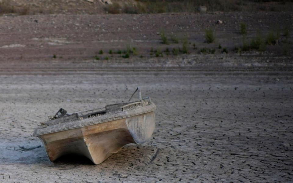  a formerly sunken boat now on cracked earth hundreds of feet from what is now the shoreline on Lake Mead - AP Photo/John Locher, File