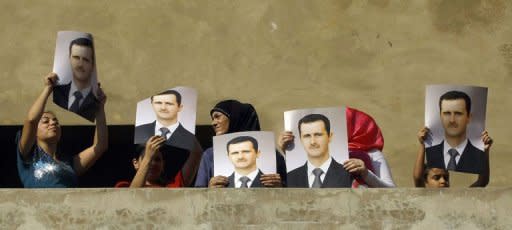 Supporters of Syrian leader Bashar al-Assad gather on a balcony of a building during a protest through the streets below in the al-Fanar district of Beirut