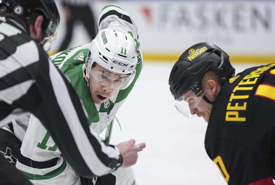 Dallas Stars' Logan Stankoven, left, lines up for a faceoff against Vancouver Canucks' Elias Pettersson during the first period of an NHL hockey game Thursday, March 28, 2024, in Vancouver, British Columbia. (Darryl Dyck/The Canadian Press via AP)