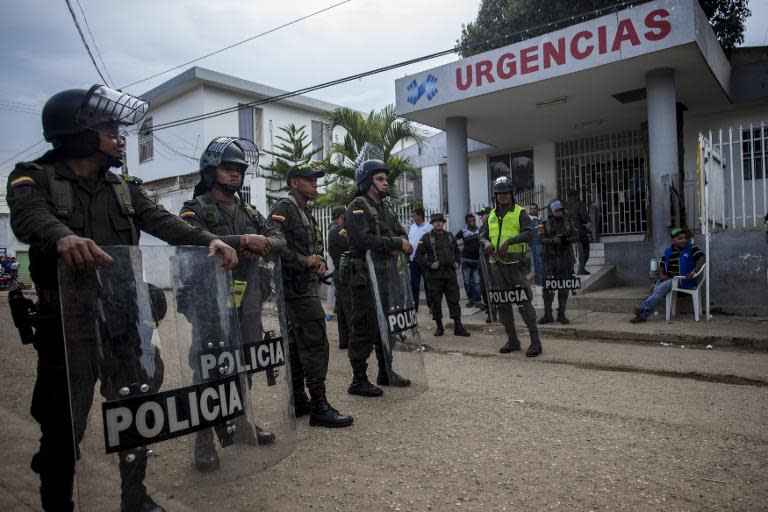 Police stand guard in front of the hospital in Carmen de Bolivar, Bolivar Province on September2, 2014