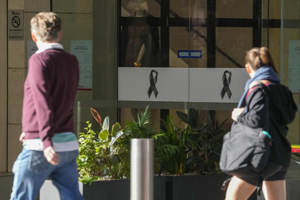 People walk past the entrance to the Westfield mall at Bondi Junction in Sydney, Thursday, April 18, 2024. The Sydney shopping mall has been opened to the public for the first time since it became the scene of a mass stabbing in which six people died, while the Australian prime minister has flagged giving citizenship to an immigrant security guard who was injured while confronting the knife-wielding attacker. (AP Photo/Mark Baker)