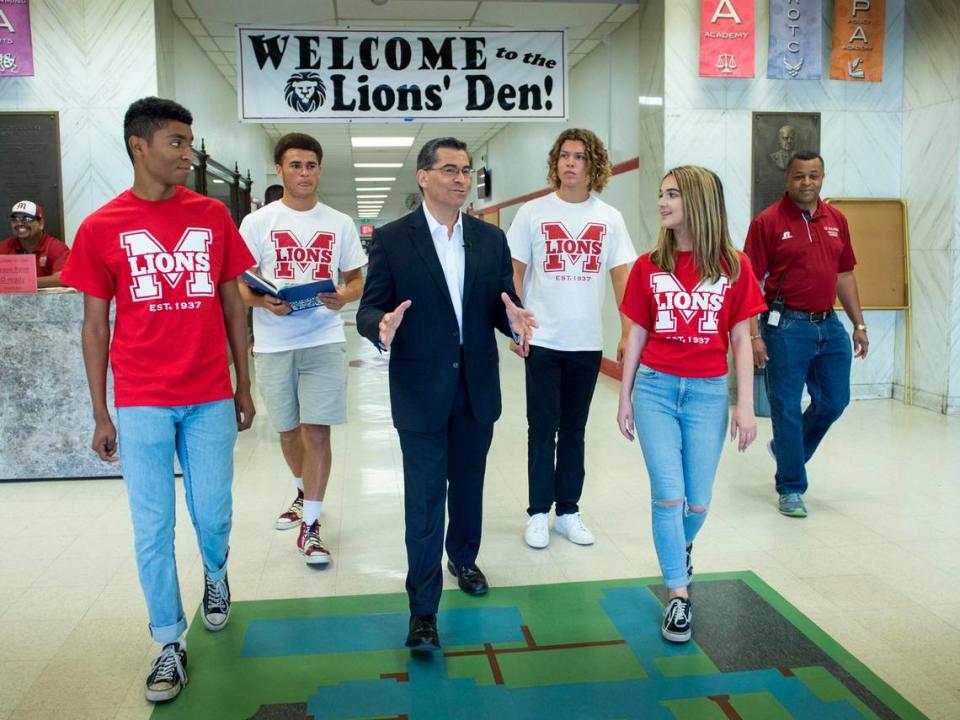 Then-California Attorney General Xavier Becerra talks with students as he tours his alma mater McClatchy High School in 2017.