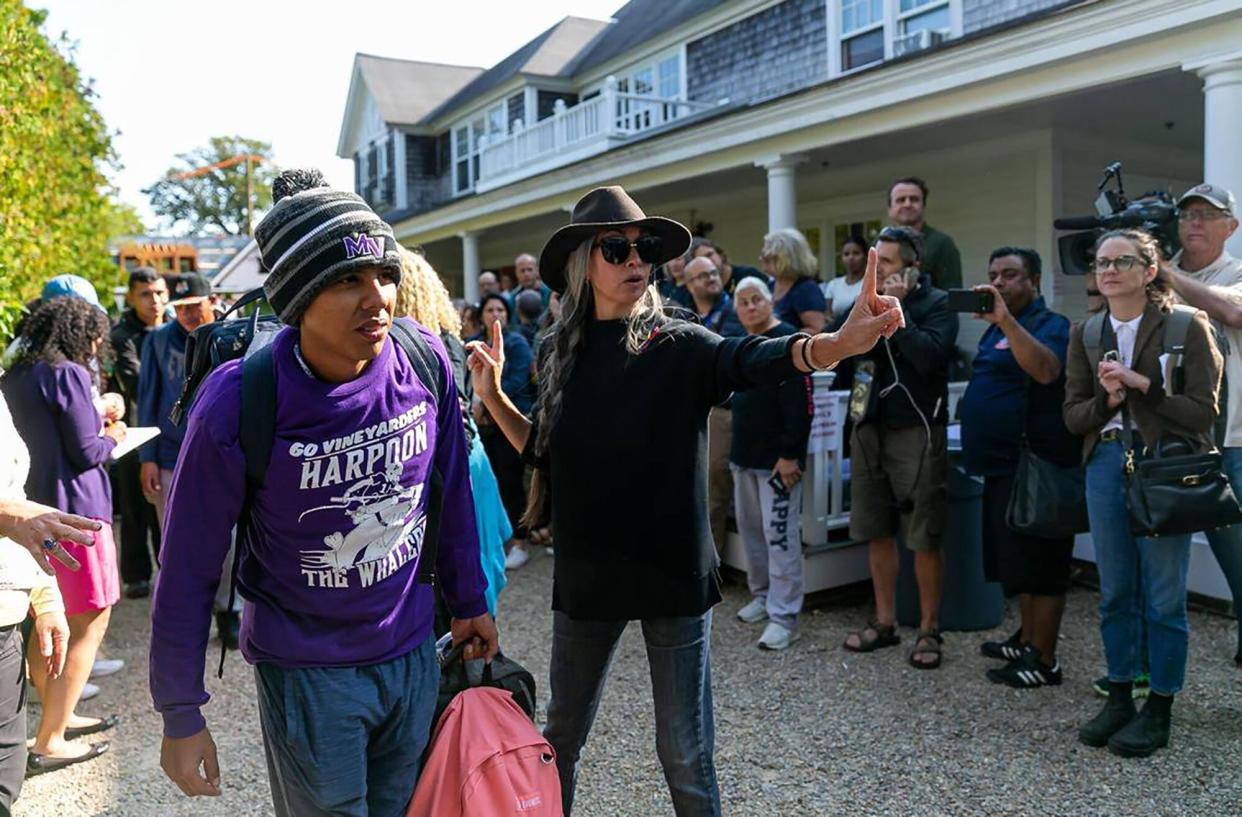 A Venezuelan migrant is led onto a bus at St. Andrews Episcopal Church on Friday, Sept. 16, 2022, in Edgartown, Massachusetts, on the island of Marthaâs Vineyard. A group of migrants was flown to the island from Texas earlier this week, leaving them stranded. They are here being transferred to a Cape Cod military base.