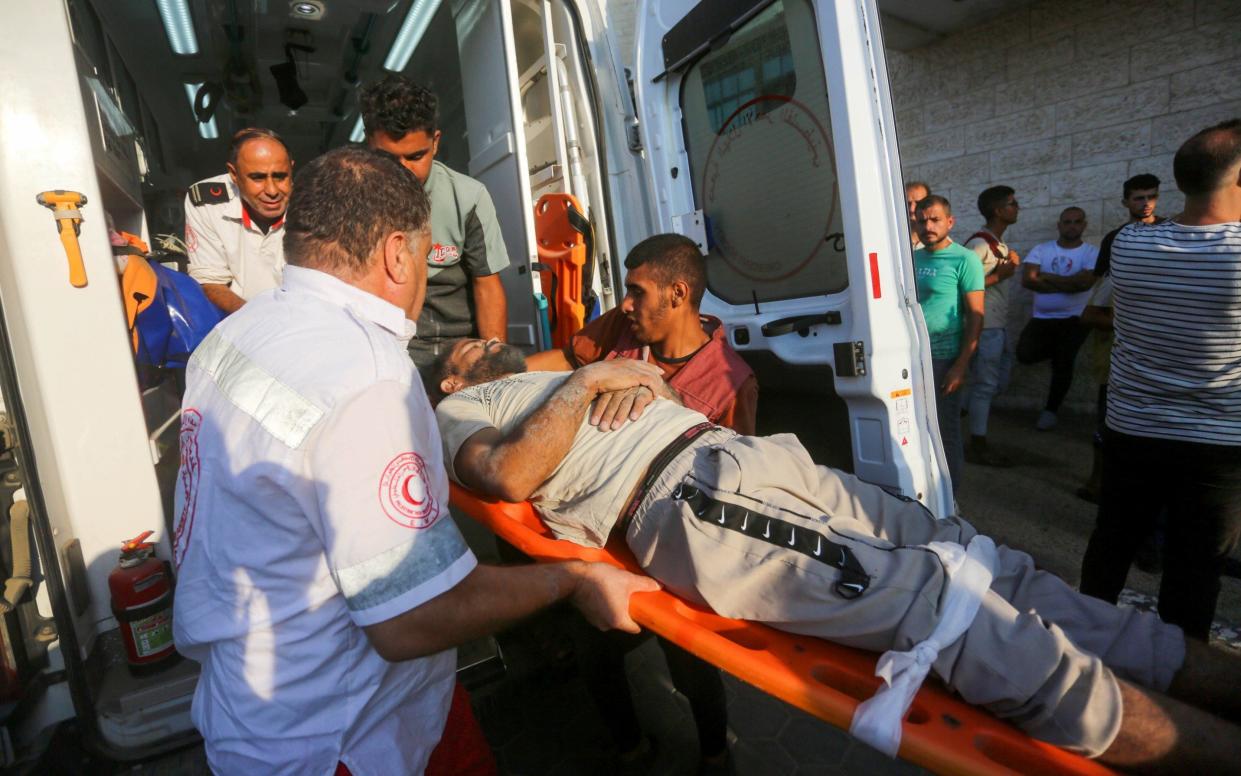 Injured Palestinians are brought to Al Aqsa Martyrs Hospital for treatment after an Israeli attack at the Bureij refugee camp in Deir al Balah, Gaza