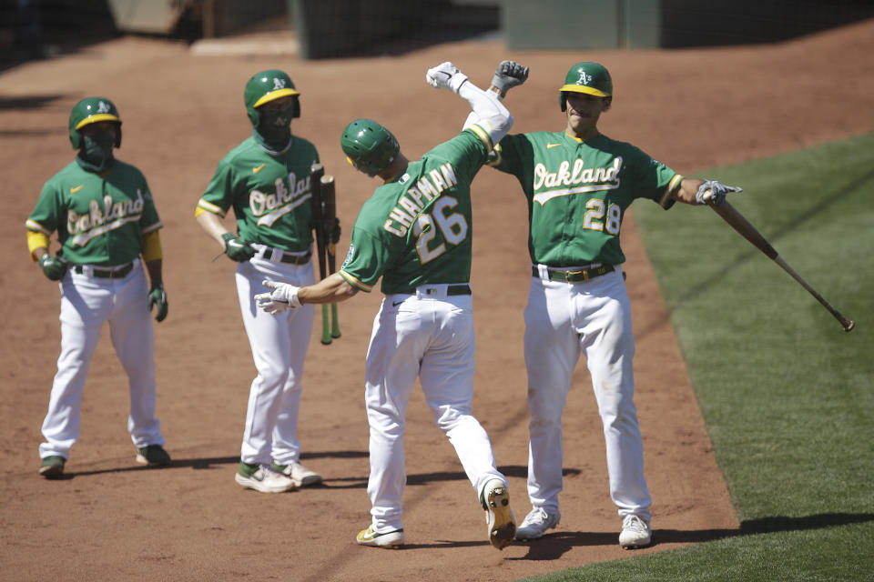 Oakland Athletics' Matt Chapman (26) celebrates with Matt Olson, right, after hitting a home run during the eighth inning of the team's baseball game against the Houston Astros on Saturday, Aug. 8, 2020, in Oakland, Calif. (AP Photo/Ben Margot)