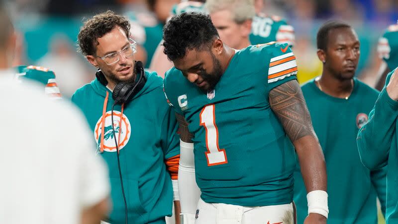 Pelatih kepala Miami Dolphins Mike McDaniel berbicara dengan quarterback Tua Tagovailoa saat ia meninggalkan permainan setelah mengalami gegar otak selama pertandingan melawan Buffalo Bills, Kamis, 12 September 2024, di Miami Gardens, Florida.