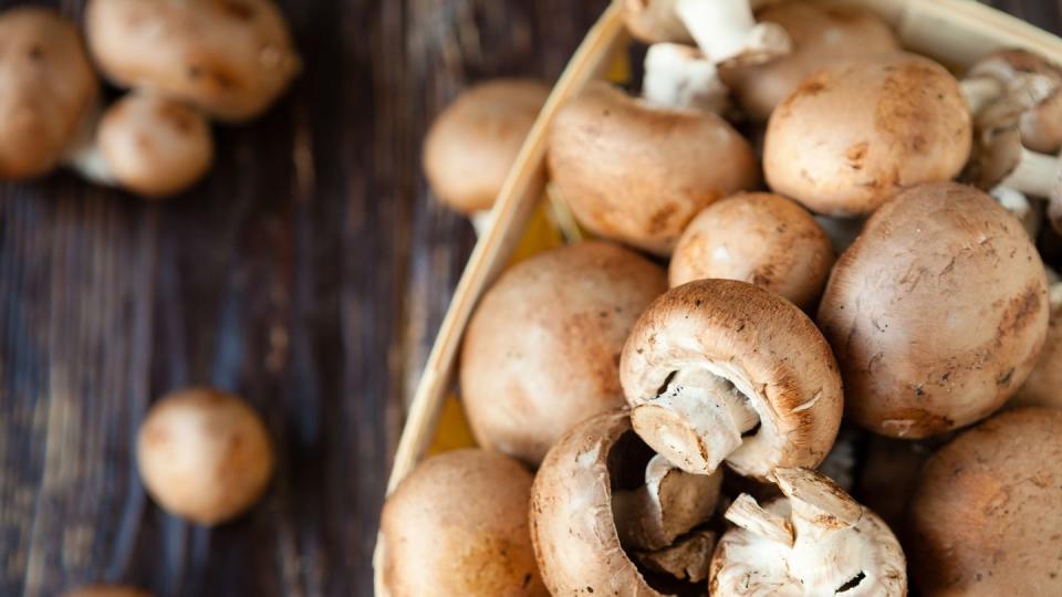 champignons in a basket on dark boards