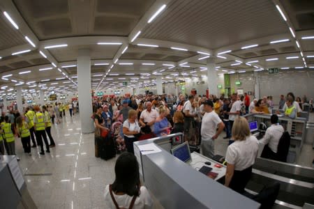 Passengers are seen at Thomas Cook check-in points at Mallorca Airport after the world's oldest travel firm collapsed, in Palma de Mallorca