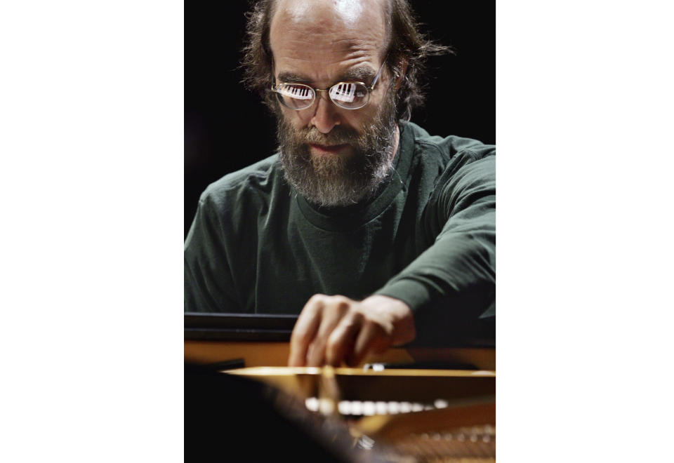 FILE - George Winston makes an adjustment on his piano during a sound check before his performance at the Cerritos Center for the Performing Arts in Cerritos, Calif., on Nov. 4, 2004. (AP Photo/Reed Saxon, File)