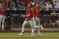 Philadelphia Phillies' Bryce Harper, center left, runs for home as he scores on an RBI-double by J.T. Realmuto during the first inning of a baseball game against the New York Mets, Sunday, Sept. 19, 2021, in New York. (AP Photo/Jason DeCrow)