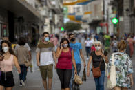 People wearing face masks to prevent the spread of coronavirus walk in downtown Madrid, Spain, Wednesday, Sept. 16, 2020. The Spanish capital will introduce selective lockdowns in urban areas where the coronavirus is spreading faster, regional health authorities announced on Tuesday. (AP Photo/Manu Fernandez)