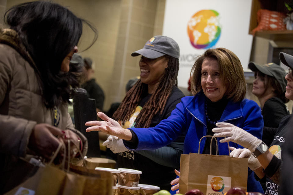 House Speaker Nancy Pelosi of Calif., center, smiles as she helps give out food at World Central Kitchen, the not-for-profit organization started by Chef Jose Andres, Tuesday, Jan. 22, 2019, in Washington. The organization devoted to providing meals in the wake of natural disasters, has set up a distribution center just blocks from the U.S. Capitol building to assist those affected by the government shutdown. (AP Photo/Andrew Harnik)