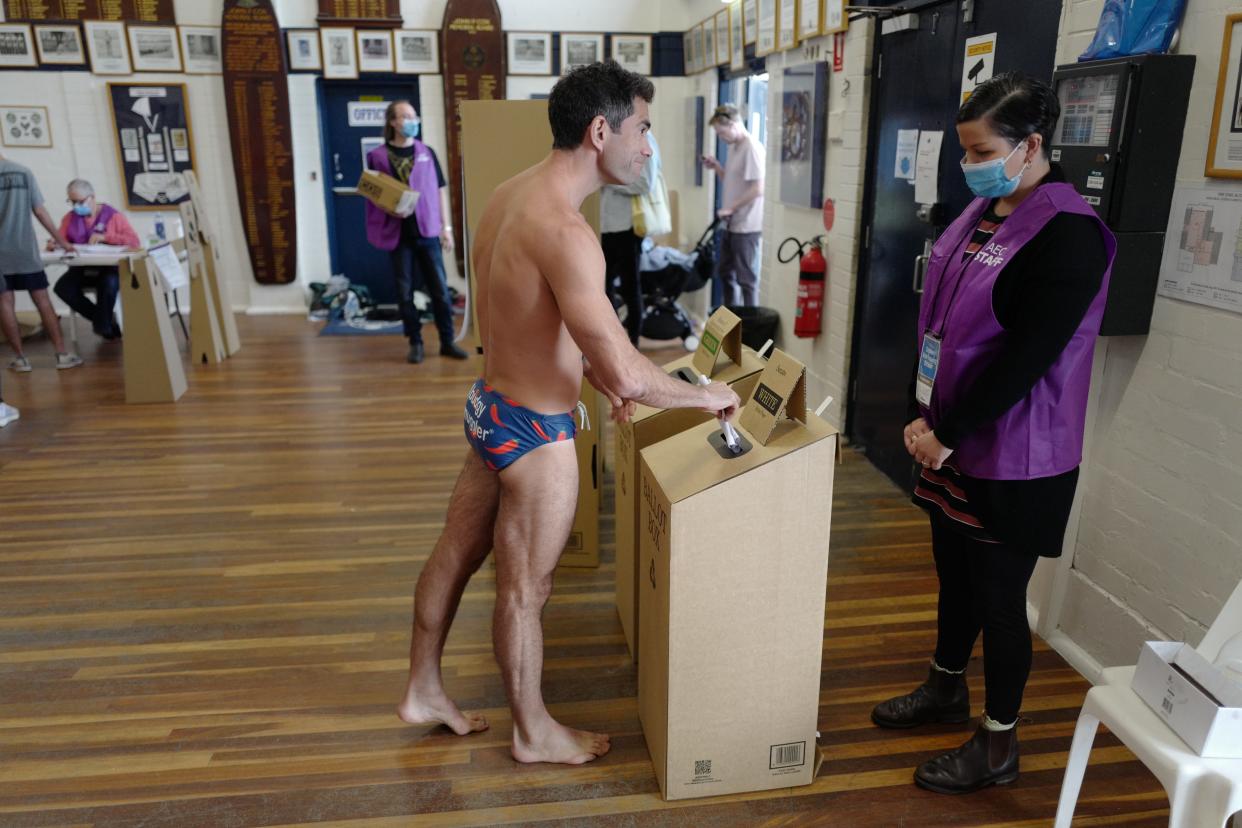 A man wearing swimwear votes inside Bondi Surf Bathers Life Saving Club in the electorate of Wentworth in Sydney, Australia, in May. Australia requires citizens to vote.