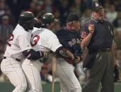 FILE - In this June 3, 1998, file photo, Boston Red Sox manager Jimy Williams, second from right, gets between home plate umpire Tim Welke, right, and batter John Valentin, while teammate Mo Vaugh restrains Valentin, who was arguing two called strikes from Baltimore Orioles pitcher Doug Johns in the fourth inning of a baseball game at Fenway Park in Boston. Valentin and Williams were ejected from the game. Automatic balls and strikes could soon be coming to the major leagues. Disappearing with that are the complaints that an umpire’s strike zone was too wide or a pitcher was getting squeezed, followed by the helmet-slamming, dirt-kicking dustups that are practically as old as the sport itself. (AP Photo/Charles Krupa, File)