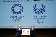 FILE - In this April 25, 2016, file photo, Tokyo 2020 Emblems Selection Committee Chairperson Ryohei Miyata, right, and its member and Japanese baseball great Sadaharu Oh hold new official logos of the 2020 Tokyo Olympics, left, and the 2020 Tokyo Paralympic Games during the unveiling ceremony in Tokyo. (AP Photo/Shizuo Kambayashi, File)