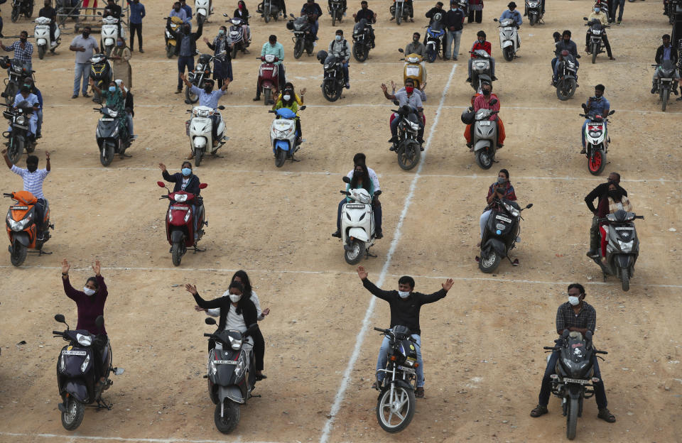 Faithful sit on their two-wheelers and pray as they attend a drive-in mass in an open area of Bethel AG Church as part of maintaining social distancing to prevent the spread of coronavirus in Bengaluru, India, Sunday, June 21, 2020. India is the fourth hardest-hit country by the COVID-19 pandemic in the world after the U.S., Russia and Brazil. (AP Photo/Aijaz Rahi)