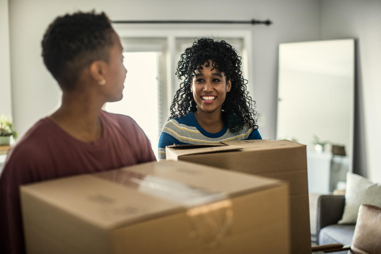 Couple carrying move in boxes into home. (Getty Images)