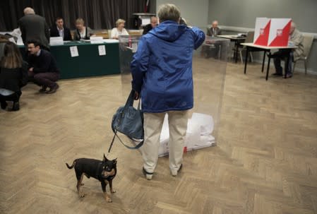 A woman casts her vote during parliamentary election at a polling station in Warsaw