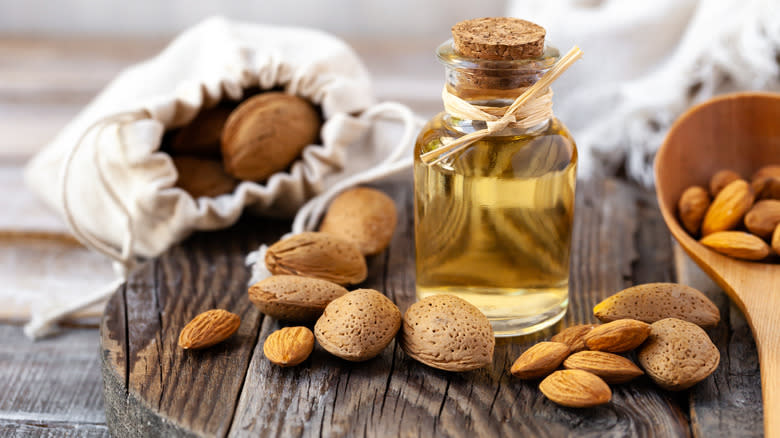 almond extract in jar and almonds laying around