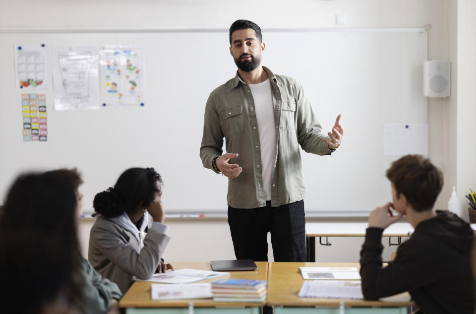 A man teaching a classrom full of students