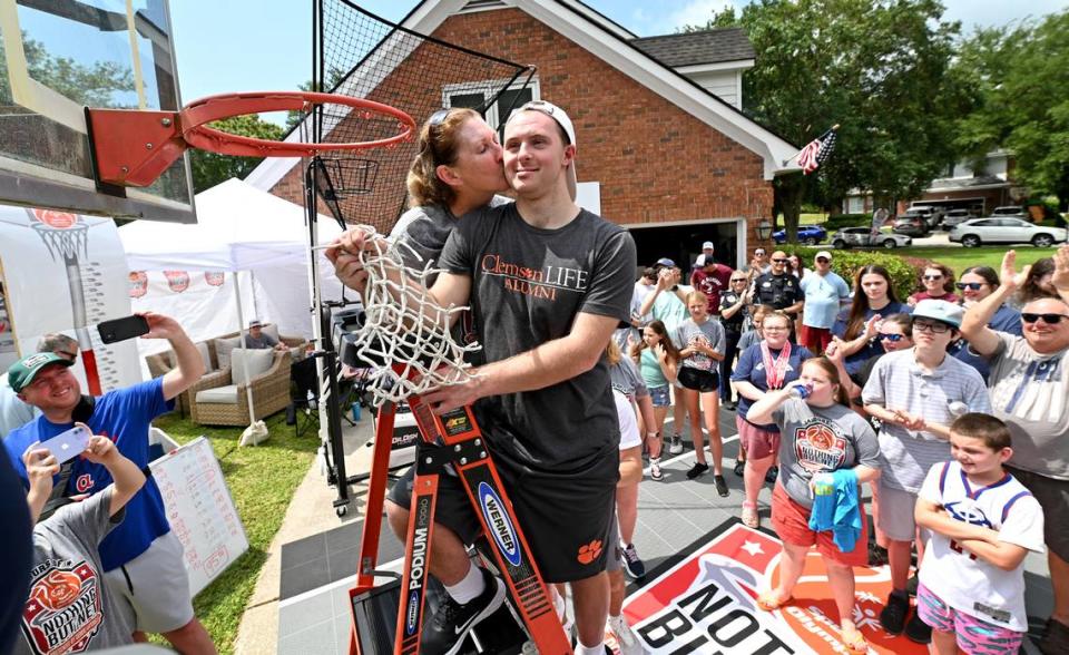 Former North Carolina State women’s basketball player and current ESPN basketball analyst Debbie Antonelli, left, kisses her son Frankie Antonelli, right, on the cheek as they celebrated her having made 2400 free throws during her “24 Hours of Nothing But Net” event to help the Special Olympics. The event started on Saturday, May 13, 2023. Antonelli shoots and makes 100 free throws every hour and shot 95% for the event, which is held in her driveway in Mount Pleasant, S.C.