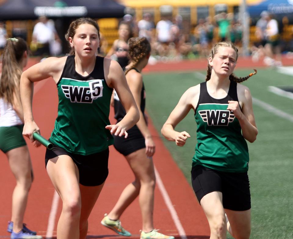 West Branch's Sophia Gregory, left, took the baton from Kaylee Burcaw during the girls 4x400-meter relay final at the Division II district track and field finals at Salem Sebo Stadium on Saturday, May 21, 2022.