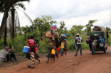 Congolese migrants expelled from Angola in a crackdown on artisanal diamond mining carry their belongings as they walk to Tshikapa in Kasai province, near the border with Angola in the Democratic Republic of the Congo, October 13, 2018. REUTERS/Giulia Paravicini