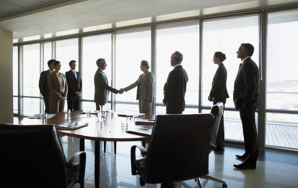 Business people shaking hands in a conference room.