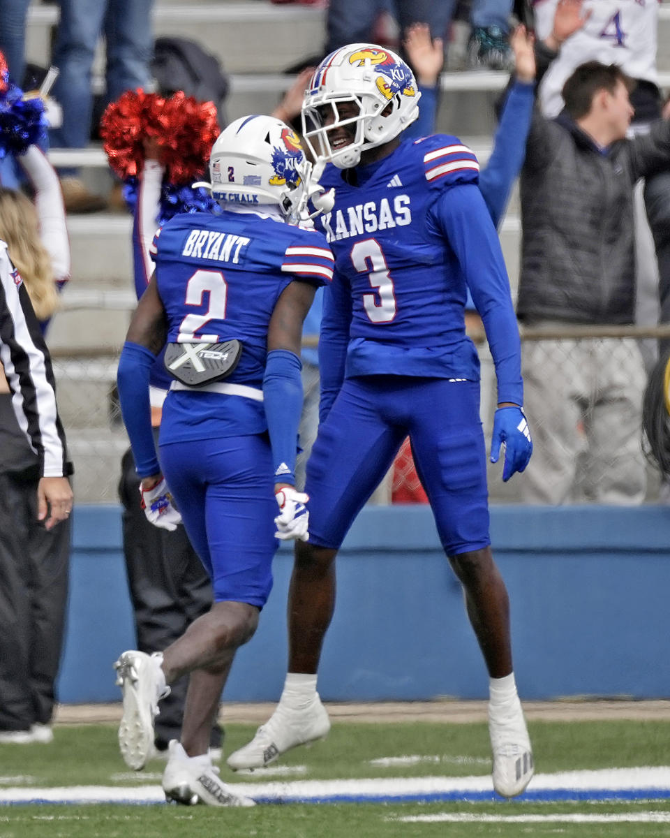 Kansas cornerback Mello Dotson (3) celebrates with cornerback Cobee Bryant (2) after intercepting a pass and scoring a touchdown during the first half of an NCAA college football game Saturday, Oct. 28, 2023, in Lawrence, Kan. (AP Photo/Charlie Riedel)