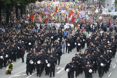 German riot police officers walk in front of protesters during demonstrations at the G20 summit in Hamburg, Germany, July 8, 2017. REUTERS/Fabian Bimmer