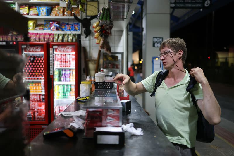 Ivan Ivanov, de 34 años, compra comida al volver a casa del trabajo, donde vive desde hace ocho meses tras abandonar su ciudad natal de Tomsk (Rusia), en Florianópolis