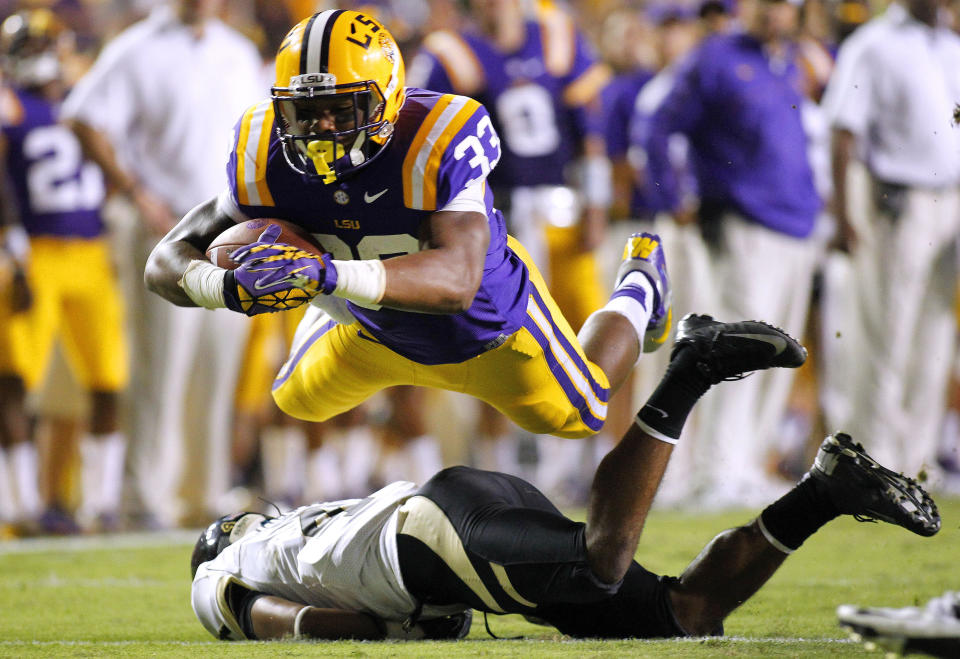 LSU Tigers running back Jeremy Hill (33) dives over Idaho Vandals cornerback Jayshawn Jordan (4) during the second half of their NCAA football game in Baton Rouge, Louisiana September 15, 2012. REUTERS/Jonathan Bachman (UNITED STATES - Tags: SPORT FOOTBALL TPX IMAGES OF THE DAY)