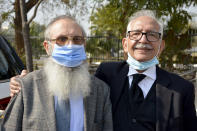 Mehmood A. Sheikh, right, defense lawyer, and Ahmed Saeed Sheikh, father of British-born Pakistani Ahmed Omar Saeed Sheikh, arrive at the Supreme Court for an appeal hearing in the Daniel Pearl case, in Islamabad, Pakistan, Thursday, Jan. 28, 2021. THe court on Thursday has ordered the release of Sheikh convicted and later acquitted in the gruesome beheading of American journalist Daniel Pearl in 2002. The court also dismissed an appeal of Sheikh's acquittal by Pearl's family. (AP Photo/Waseem Khan)