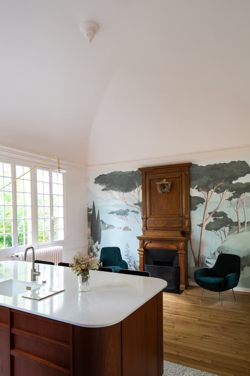 Wooden fireplace in newly renovated kitchen with tree mural.