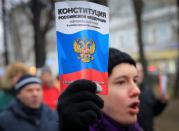 A opposition supporter holds a copy of Russia's constitution during a rally against constitutional reforms proposed by President Vladimir Putin, in Moscow