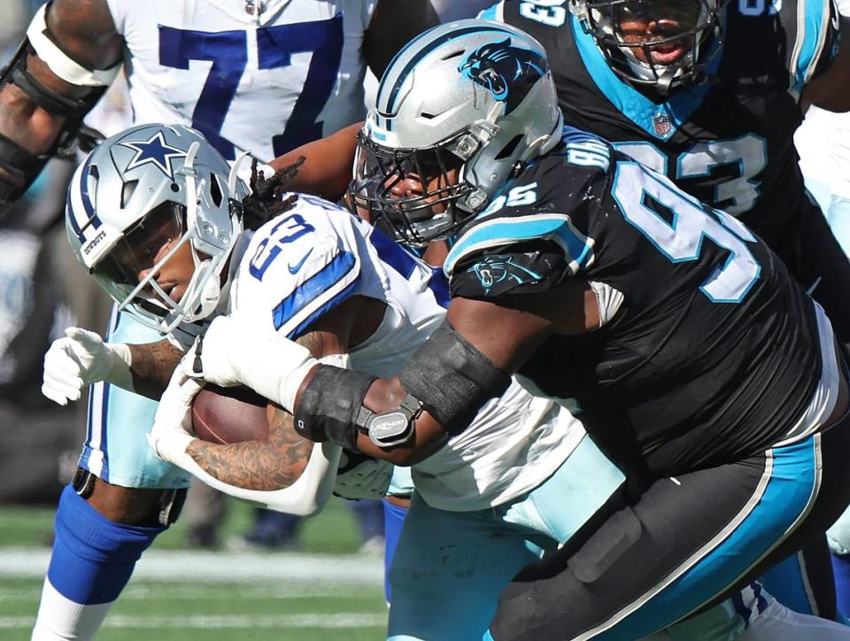 Carolina Panthers defensive end Derrick Brown, right, makes the tackle on Dallas Cowboys running back Rico Dowdle, left, during second-quarter action at Bank of America Stadium in Charlotte, NC on Sunday, November 19, 2023.