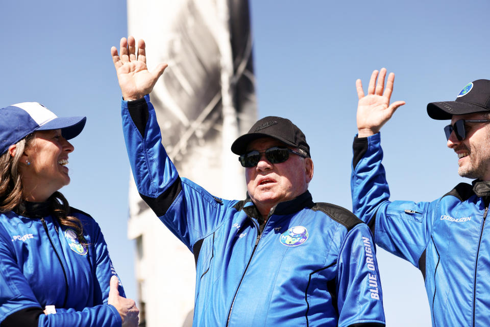 Blue Origins vice president of mission and flight operations Audrey Powers, Star Trek actor William Shatner, and Planet Labs co-founder Chris Boshuizen wave during a media availability on the landing pad of Blue Origin’s New Shepard after they flew into space on October 13, 2021 near Van Horn, Texas. Shatner became the oldest person to fly into space on the ten minute flight. They flew aboard mission NS-18, the second human spaceflight for the company which is owned by Amazon founder Jeff Bezos. (Photo by Mario Tama/Getty Images)