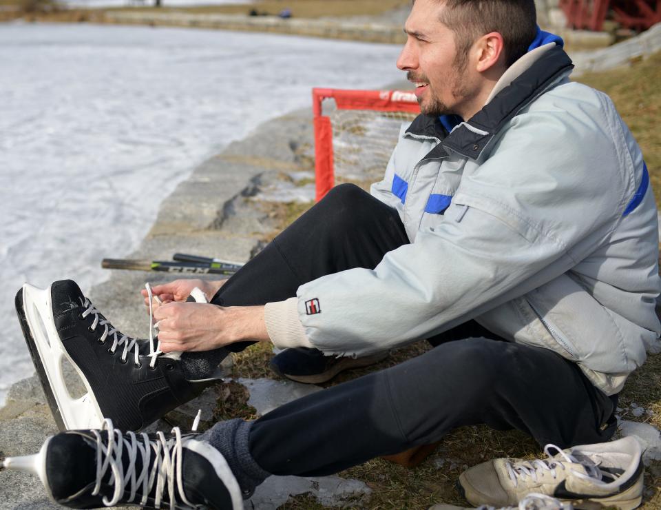 Austin Alexander laces up his skates ahead of a game at Elm Park Sunday.