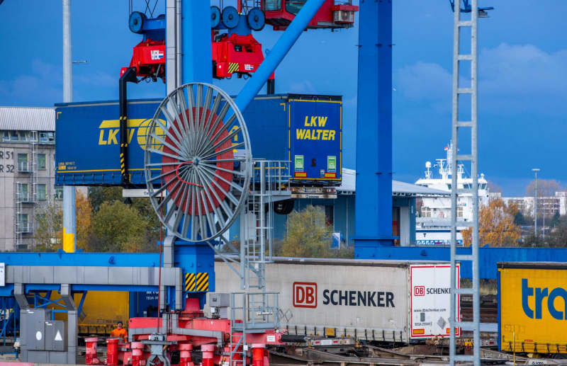 A trailer from logistics company DB Schenker is loaded onto a train at the seaport together with other trailers. Politically uncertain times are a bad omen for the export-dependent German economy and a study recommends that companies adapt their strategy. Jens Büttner/dpa