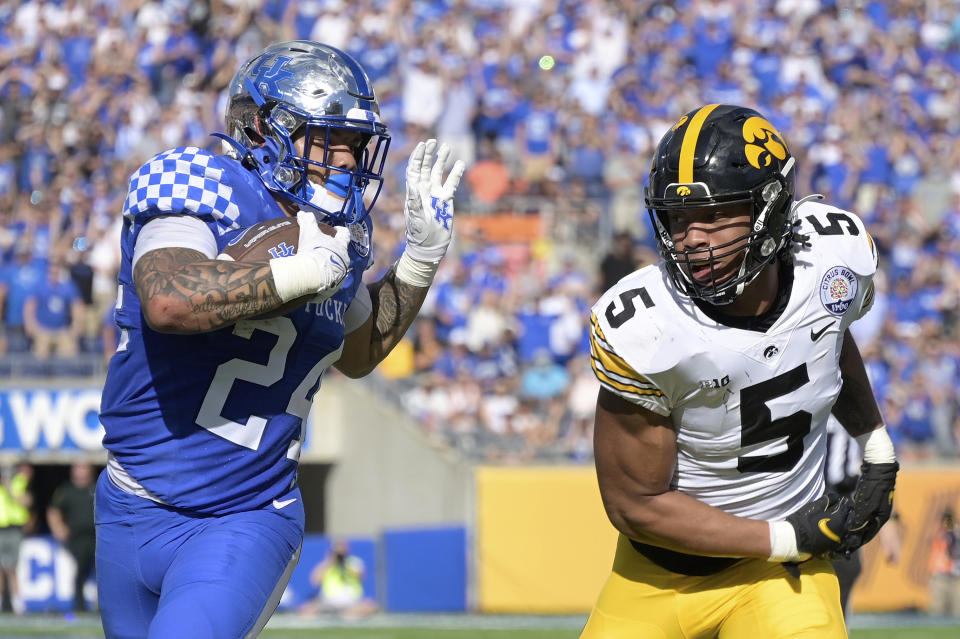 Kentucky running back Chris Rodriguez Jr. (24) rushes for yardage in front of Iowa linebacker Jestin Jacobs (5) during the first half of the Citrus Bowl NCAA college football game, Saturday, Jan. 1, 2022, in Orlando, Fla. (AP Photo/Phelan M. Ebenhack)