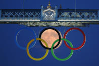 The full moon rises through the Olympic Rings hanging beneath Tower Bridge during the London 2012 Olympic Games August 3, 2012. REUTERS/Luke MacGregor (BRITAIN - Tags: SPORT OLYMPICS CITYSPACE TPX IMAGES OF THE DAY ENVIRONMENT)