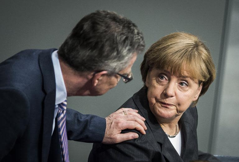 German Interior Minister Thomas de Maiziere -- who denies charges of misleading lawmakers over the "BND affair" -- speaks with Chancellor Angela Merkel at the Bundestag in Berlin, on January 15, 2015