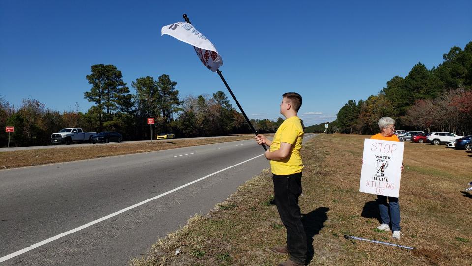 Aiden Autry, a Gray's Creek High School freshman, left, and Vickie Mullins participate in a protest against GenX contamination and the Chemours company near the company's sign on N.C. 87 at the Cumberland and Bladen County lines.