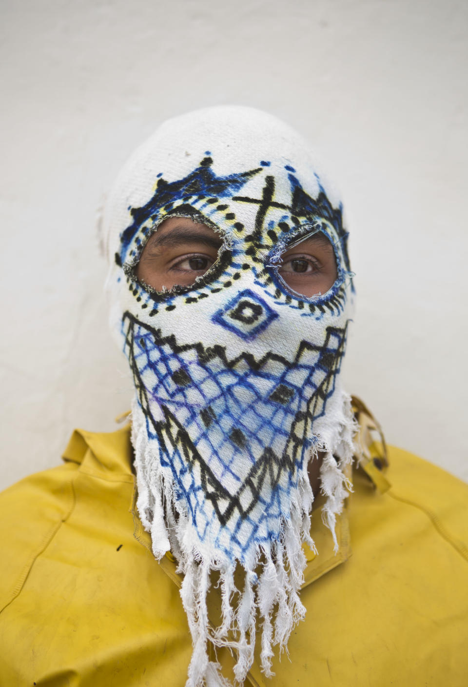 In this April 18, 2014 photo, a youth with a mask dressed as a "Judas" poses for a picture during a break while participate in "Los Encadenados," or The Chained Ones procession on Good Friday during Holy Week in Masatepe, Nicaragua. The youth played the part of Judas who is carried away in chains. They attach long chains and then drag him around, sometimes symbolically kicking and beating him, as punishment for betraying Jesus Christ. (AP Photo/Esteban Felix)